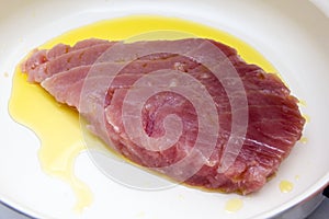 Slice of raw tuna with oil in the pan