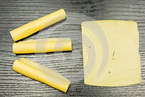 Slice and rolls of yellow cheese.