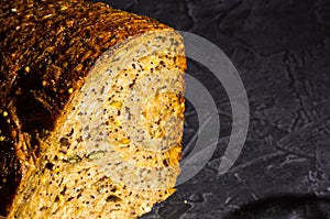 Slice of rustic natural yeast-free bread with flax, poppy seeds, sesame seeds, millet, pumpkin and sunflower seeds, on a