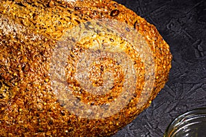 Slice of rustic natural yeast-free bread with flax, poppy seeds, sesame seeds, millet, pumpkin and sunflower seeds, on a