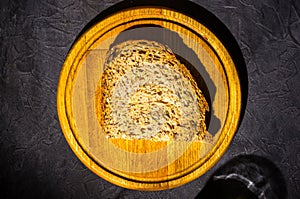 Slice of rustic natural yeast-free bread with flax, poppy seeds, sesame seeds, millet, pumpkin and sunflower seeds, on a