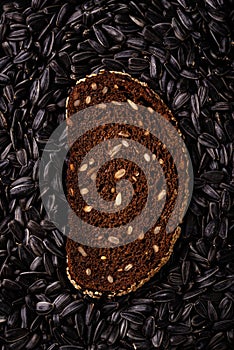 Slice of rye bread on black seed background
