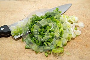 Slice scallions with knife on cutting board