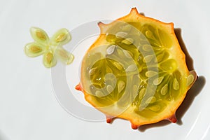 Slice and seeds of kiwano, exotic vegetable cucumis metuliferus closeup. Soft focus. Vegetarian food