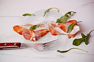 Slice of smoked ham on fork on a white background