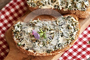 A slice of sourdough bread with nettle butter - homemade bread spread made of wild edible plants harvested in spring, with