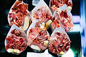 Slice spanish hamon in barcelona market, jamon iberico isolated, traditional national spain meat in store, serrano prosciutto food