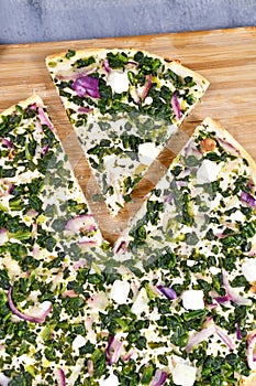 Slice of `Tarte Flambee` or `Flammkuchen`, a thin pizza-like baked pie from German-French Alsace region, vegetarian variation