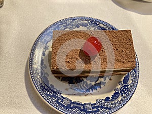 Slice of tiramisu cake for desset with a cherry on top
