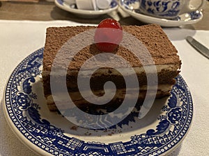Slice of tiramisu cake for desset with a cherry on top