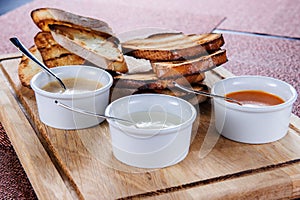 Slice of toast roasted in breaded with cheese and sesame slipped in a sauce on a wooden board