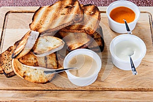 Slice of toast roasted in breaded with cheese and sesame slipped in a sauce on a wooden board