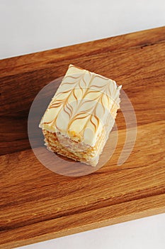 Slice of traditional Hungarian and Austrian Esterhazy cake on wooden board
