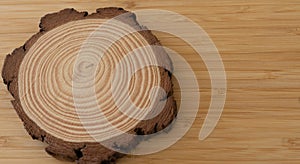 Slice of tree with annual circles and bark on a wooden background