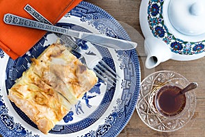 Slice of Turkish borek served with a cup of tea