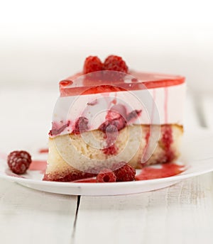 Slice of vanilla sponge cake with yogurt souffle and raspberry j