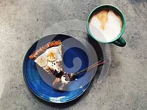 Slice of vegan banoffee pie on plate with fork, espresso drink