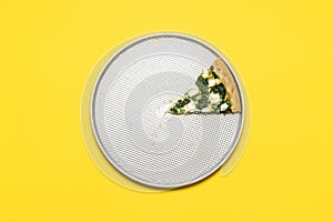 Slice of vegetarian pizza on a tray, top view on a yellow background