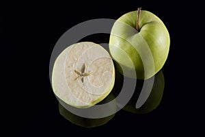 Sliced apple on black mirror