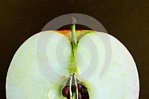 Sliced apple macro image on dark background. Close up of fresh ripe fruit with core and kernels