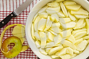 Sliced apples with peel and knife for an apple pie