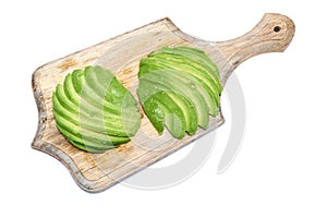 Sliced avocado fruit on wooden chopping board isolated on white background
