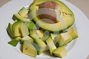 Sliced avocado is served on a ready-made white plate