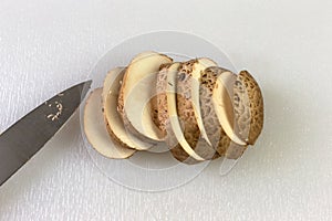 Sliced baby bella mushroom with a knife