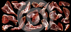 Sliced bacon on black background, raw ham strips
