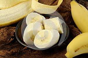 Sliced banana in bowl on wooden