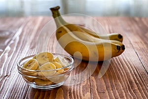 Sliced banana in bowl on wooden table