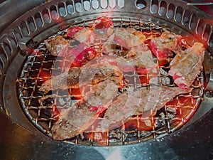 Sliced beef on hot charcoal grill, restaurant.