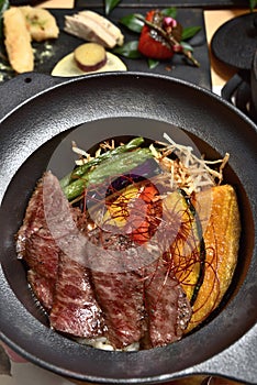 Sliced beef steak with fried vegetables cover rice