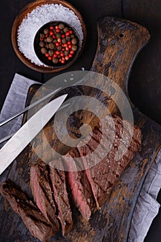 Sliced beef steak with knife and fork and spices