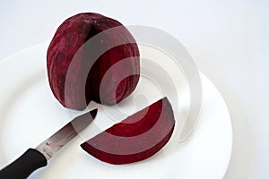 Sliced beetroot on white plate with knife