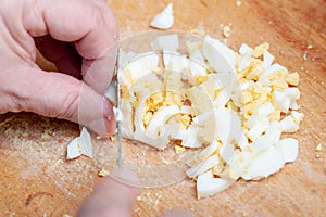 sliced boiled chicken eggs on the kitchen board. preparation of the ingredient for the dish. homemade cooking