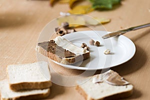 Sliced bread in plate with chocolate cream and nuts