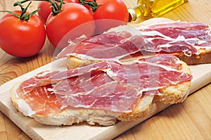 Sliced of bread with serrano ham served as tapas