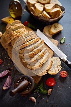 sliced bread on wooden cutting board on dark table