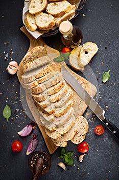 sliced bread on wooden cutting board on dark table