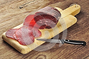Sliced bresaola on a cutting board photo