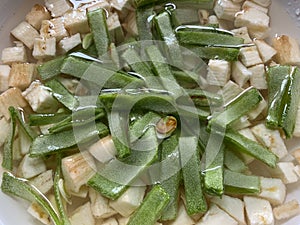 Sliced broad beans and raw plantain cubes soaked in water