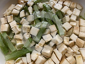 Sliced broad beans and raw plantain cubes soaked in water