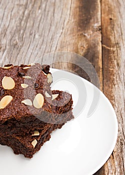 Sliced brownies on glass plate over wooden table. Favorite desse