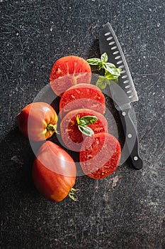 Sliced bull heart tomatoes on black table