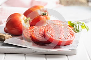 Sliced bull heart tomatoes on cutting board