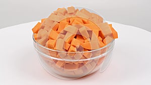 Sliced butternut squash in a glass bowl Cucurbita moschata, butternut pumpkin or guitar gramma isolated on white.