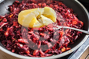 Sliced carrot, red beet and onion with cooked potato on top