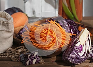 Sliced carrots and red cabbage on a wooden dish. Harvesting products. Kitchen. Fermented, canned vegetarian food. The concept of