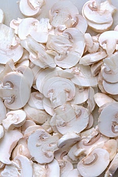 Sliced champignon mushrooms close up. Healthy food concept. Cooking background. Selective focus